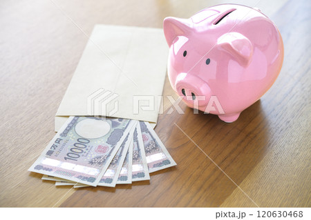 ブタの貯金箱と封筒に入れられたお札（新紙幣） 120630468