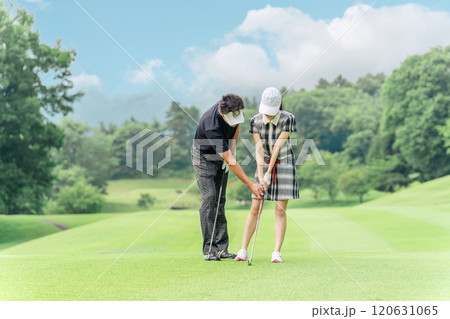 ゴルフ場でゴルフレッスンするゴルファーの男女（ラウンドレッスン） 120631065