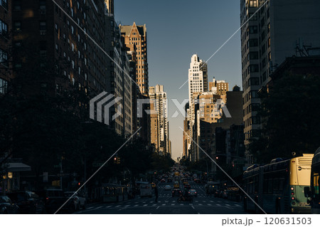 The light of summer sunset shines between the buildings on Street in Manhattan, New York City, usa - may 2th 2023 120631503