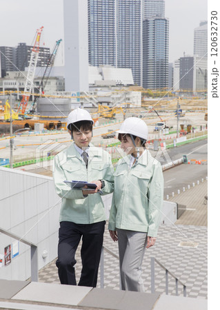 工事現場で打ち合わせをする作業員男女 120632730