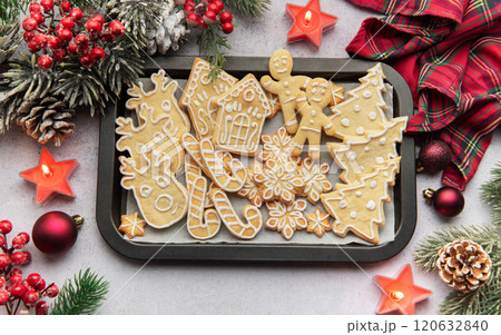 Christmas gingerbread cookies on baking tray with festive decorations Christmas gingerbread cookies on baking tray with festive decorations 120632840