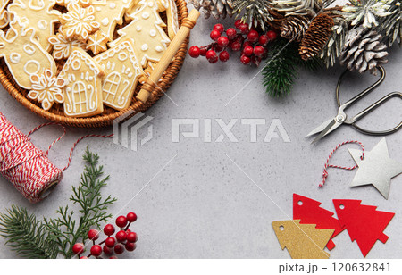 Christmas decoration with gingerbread cookies, pine cones, and festive ornaments creating cozy holiday atmosphere Christmas decoration with gingerbread cookies, pine cones, and festive ornaments creating cozy holiday atmosphere 120632841