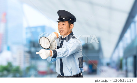 都市の駅前で拡声器を使って誘導する男性警備員 120633117