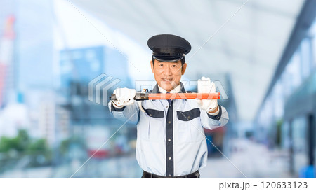 都市の駅前で交通整理する男性警備員 120633123