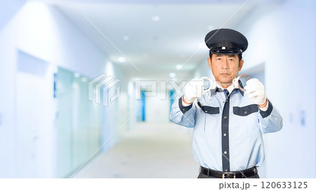 ビルの通路で手錠を見せる男性警察官 120633125
