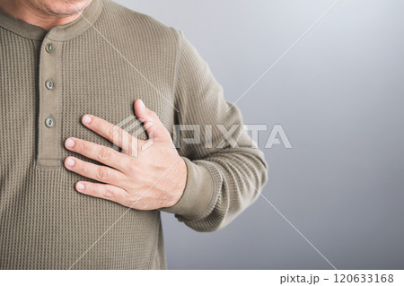 Man touches his left chest, indicating pain that may signal heart or cardiovascular issues. Image emphasizes the importance of early detection and awareness in preventing heart-related health risks 120633168