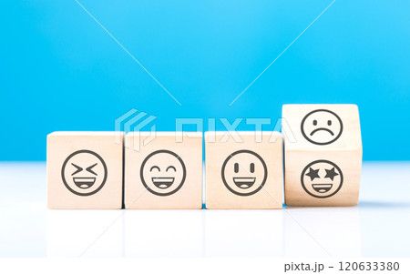 Wooden blocks displaying a sad face transitioning to a happy face, symbolizing a shift from negativity to positivity. Final block turns from sad to happy, highlighting the power of a positive outlook Wooden blocks displaying a sad face transitioning to a happy face, symbolizing a shift from negativity to positivity. Final block turns from sad to happy, highlighting the power of a positive outlook 120633380