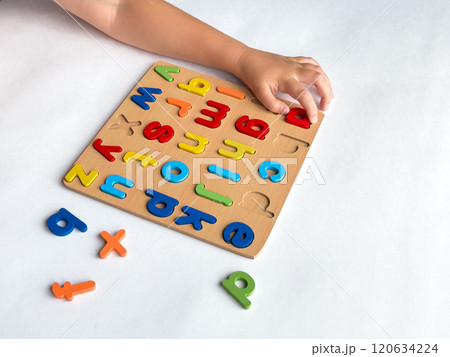 Child learning with colorful alphabet puzzle on white background 120634224