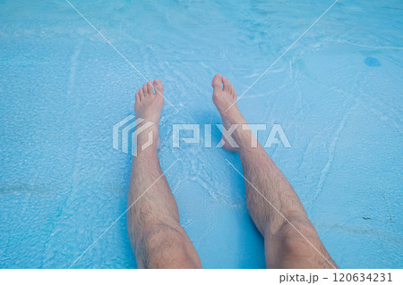 波のプールの浅瀬に座る40代男性の足 120634231