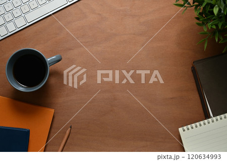 Wooden desk with cup of coffee, notepad and computer keyboard. Top view, Flat lay Wooden desk with cup of coffee, notepad and computer keyboard. Top view, Flat lay 120634993