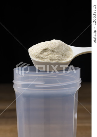 シェイカーに計量スプーンでプロテインを入れる 120635515