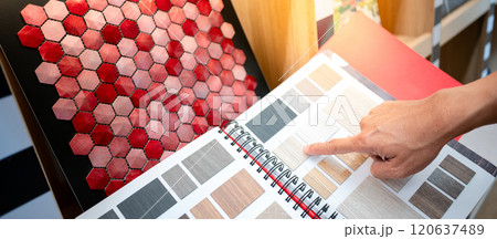 Designer hand pointing at wooden laminate swatch collection in material sample catalog Designer hand pointing at wooden laminate swatch collection in material sample catalog 120637489