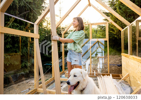 Female Carpenter with Her Dog in Greenhouse 120638033