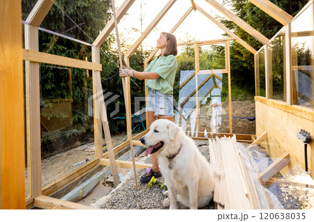 Female Carpenter with Her Dog in Greenhouse Female Carpenter with Her Dog in Greenhouse 120638035