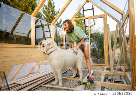 Female Carpenter Playing with Her Dog 120638050