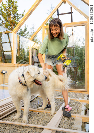 Female Carpenter Playing with Her Dog Female Carpenter Playing with Her Dog 120638061