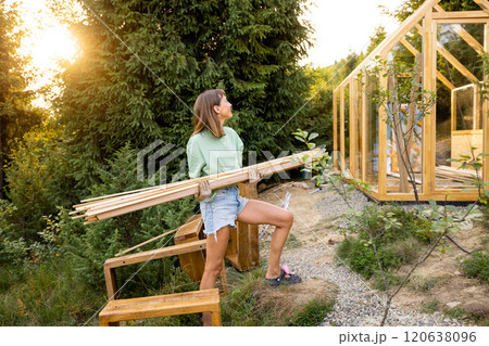 Female Carpenter Carrying Wooden Planks 120638096