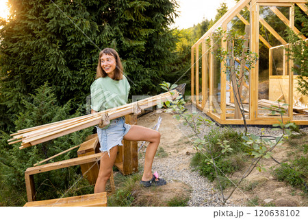 Female Carpenter Carrying Wooden Planks 120638102