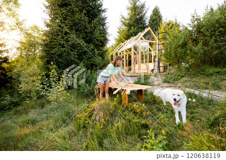 Woman building greenhouse at backyard 120638119