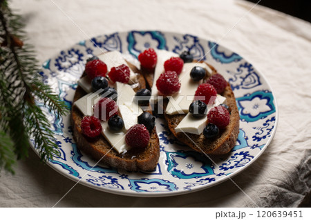 A plate of bread with blue and white designs and blueberries A plate of bread with blue and white designs and blueberries 120639451