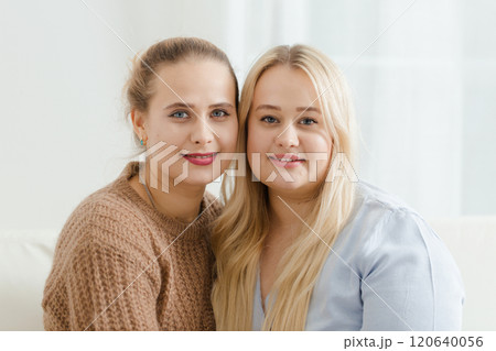 Close-up portrait of two fair-haired plump women on a light background Close-up portrait of two fair-haired plump women on a light background 120640056