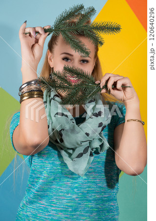 A woman covered her face and smiles. Behind her is a colorful background A woman covered her face and smiles. Behind her is a colorful background 120640296