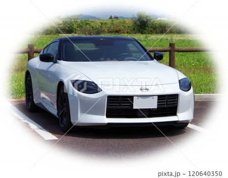 快晴の休日に白い車体のスポーツカーでドライブに出掛けて公園の駐車場で休憩して景色を眺めているイメージ 120640350