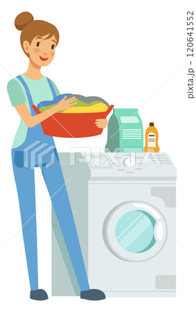 A woman is standing in front of a washing machine and dryer 120641552