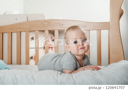 Curious Baby Standing in a Wooden Crib 120641707