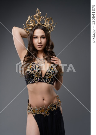 Elegant dancer showcases intricate costume with ornate details in studio 120641879