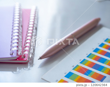 テーブルに置かれたグラフと手帳 テーブルに置かれたグラフと手帳 120642364