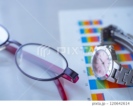 テーブルに置かれたグラフとメガネと腕時計 テーブルに置かれたグラフとメガネと腕時計 120642614