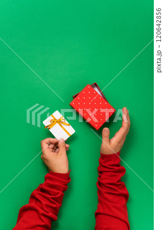 Minimalistic design with woman hands holding a plastic card for Christmas or celebrations. Holiday concept with hands displaying card, perfect for gifting or shopping during sales, celebrations 120642856