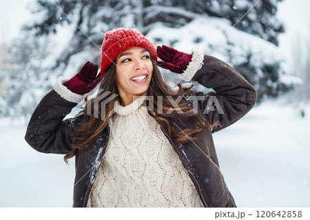 Young woman laughs and throws snow in a winter snowy park. Holidays, rest, travel concept. 120642858