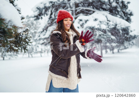 Young woman laughs and throws snow in a winter snowy park. Holidays, rest, travel concept. 120642860