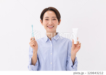笑顔で歯ブラシと歯磨き粉を持つ女性のイメージ (写真素材) 笑顔で歯ブラシと歯磨き粉を持つ女性のイメージ (写真素材) 120643212