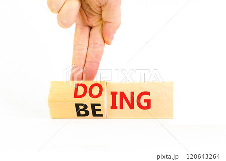 Doing or being symbol. Concept word Doing and Being on wooden cubes. Businessman hand. Beautiful white table white background. Business doing or being concept. Copy space. Doing or being symbol. Concept word Doing and Being on wooden cubes. Businessman hand. Beautiful white table white background. Business doing or being concept. Copy space. 120643264