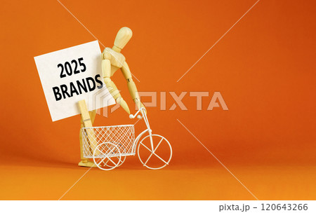 Planning 2025 brands new year symbol. Concept words 2025 Brands on beautiful white paper on wooden clothespin. Bicycle. Beautiful orange background. Business 2025 brands new year concept. Copy space. 120643266