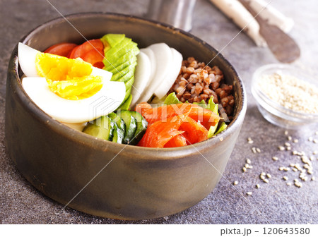 Healthy vegan nutritious bowl with buckwheat. Salad of avocado, salmon, buckwheat, egg and tomato, top view Healthy vegan nutritious bowl with buckwheat. Salad of avocado, salmon, buckwheat, egg and tomato, top view 120643580