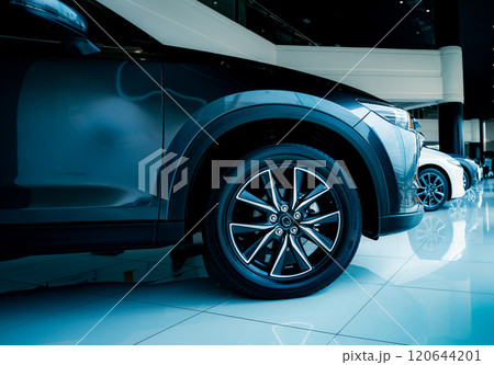 Luxury automotive showcasing premium vehicle design details in contemporary car showroom. Elegant modern car display in prestigious dealership showroom. Vehicle premium features and alloy wheels. 120644201