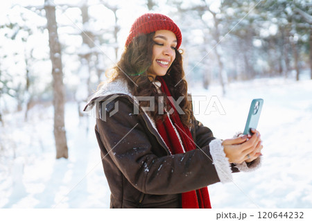 Smiling young woman taking selfie in winter forest. Winter holiday. Smiling young woman taking selfie in winter forest. Winter holiday. 120644232