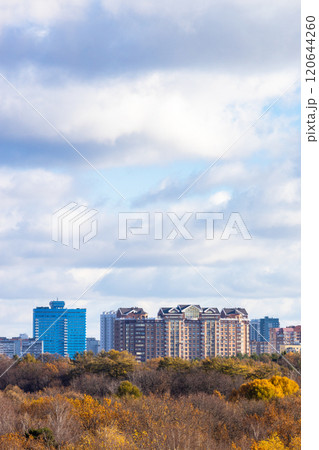 blue cloudy sky over buildings and colorful park 120644260