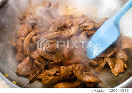 pieces of turkey fillet meat is fried in wok 120644556