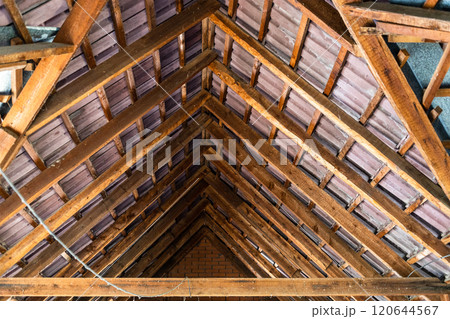 inside view of wood rafters supporting roof tiles 120644567
