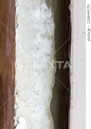 first layers of fresh plaster on window slope 120644570
