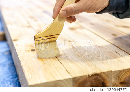 木材に防腐剤を塗っている 木材に防腐剤を塗っている 120644775