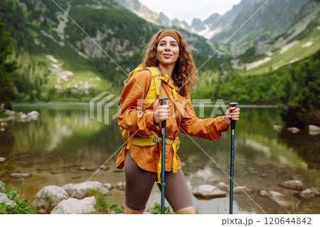 Travel Slovakia, Europe. Tourist with a yellow backpack stands against the backdrop of alpine lake. Travel Slovakia, Europe. Tourist with a yellow backpack stands against the backdrop of alpine lake. 120644842