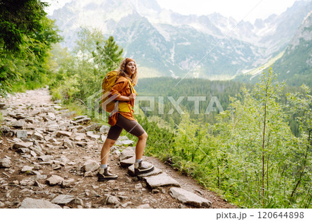 Young traveler woman with a yellow backpack on a cliff. Sports concept, traveler. Active lifestyle. 120644898