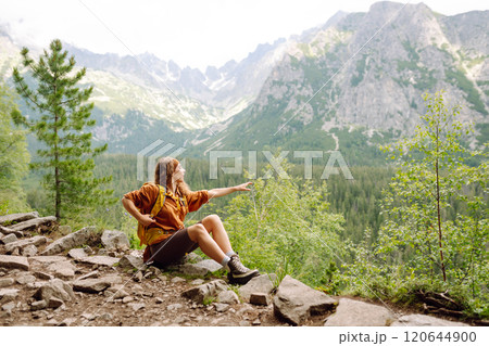 Young traveler woman with a yellow backpack on a cliff. Sports concept, traveler. Active lifestyle. 120644900