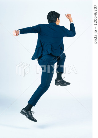 ジャンプする若い男性ビジネスパーソンの後ろ姿の全身写真 ジャンプする若い男性ビジネスパーソンの後ろ姿の全身写真 120646207